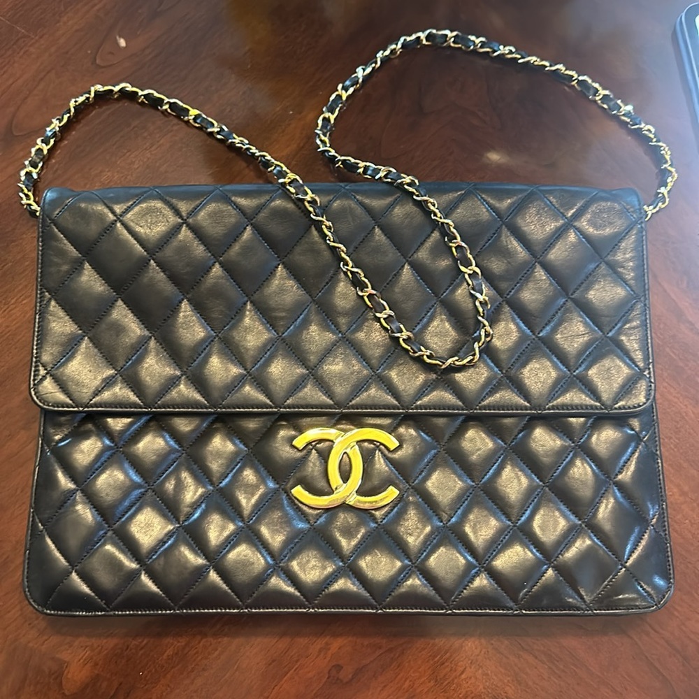 CHANEL vintage black XXL classic flap clutch bag with shoulder strap.